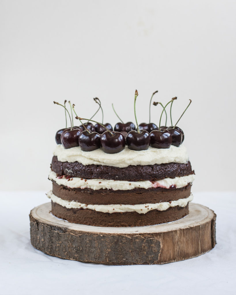 This Black Forest Cake is a three-layers chocolate cake with kirsch syrup, mascarpone cream and cherries, sprinkled with shredded chocolate and decorated with fresh cherries.